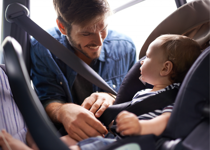 Dad taking baby out of car restraint