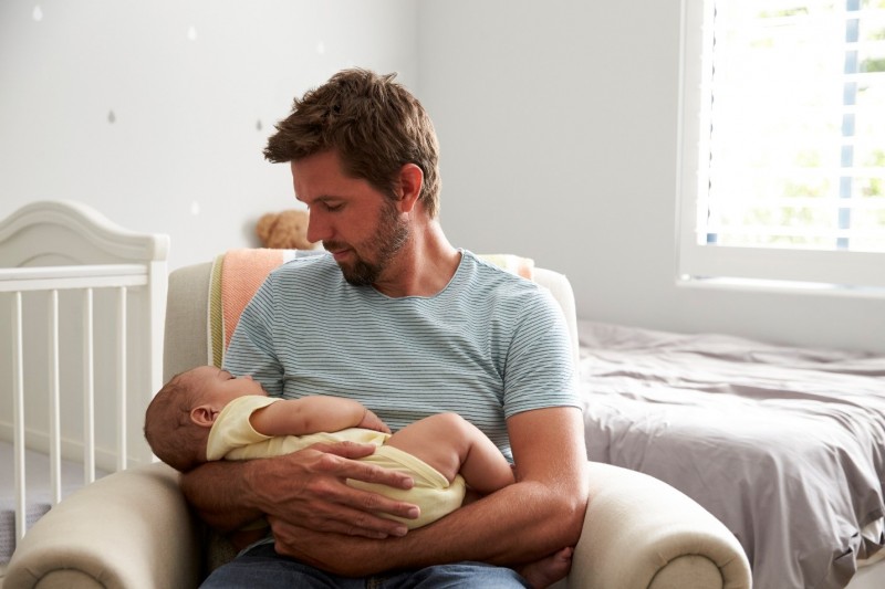 Dad holding baby in nursery