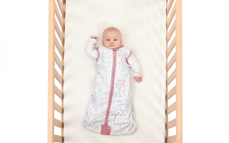 Baby in cot image for mattress wrapping article