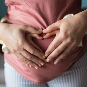Family holding pregnant mum