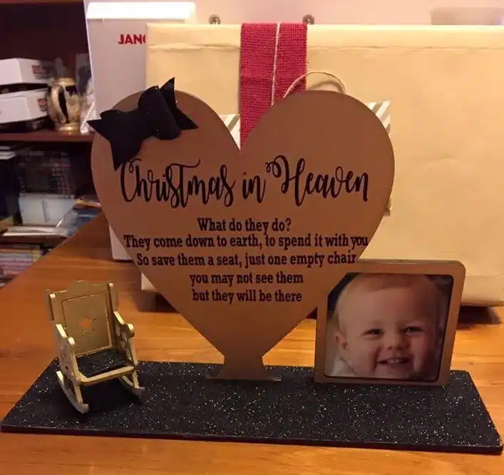 Image of a photo frame with a smiling Charlotte and a love heart to the side with the words: Christmas in Heaven. What do they do? They come down to earth, to spend it with you. So save them a seat, just one empty chair you may not see them but they will be there. 

On the other side of the heart is a mini golden rocking chair.