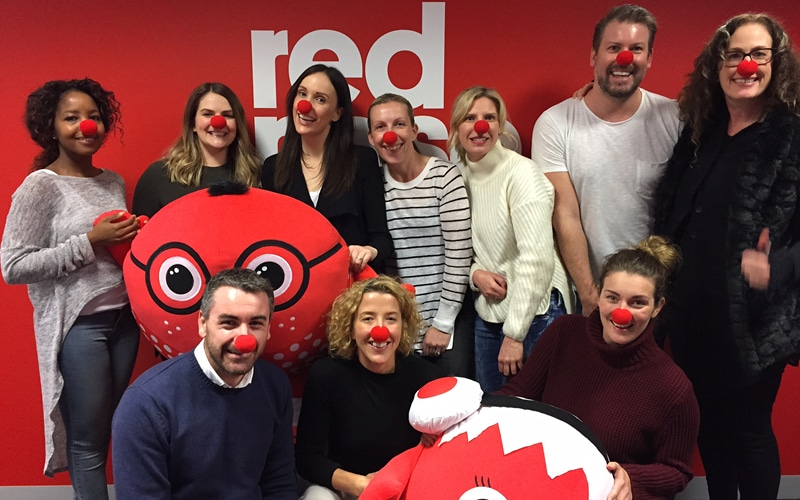Group of people looking happy wearing Red Noses