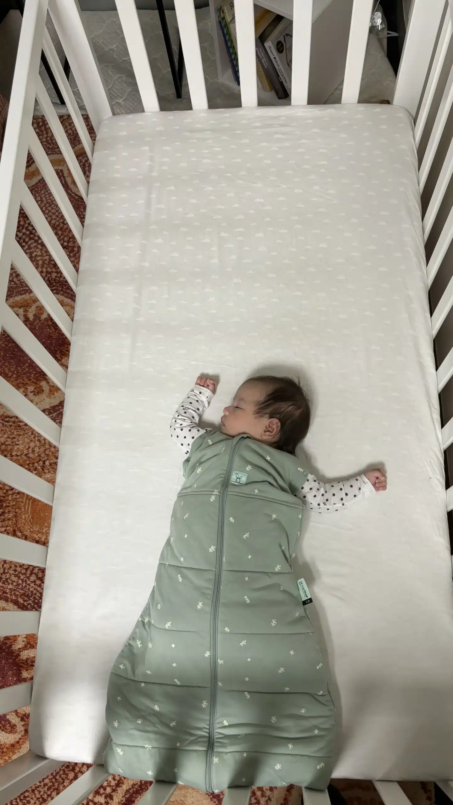 Baby sleeping in a cot wearing a sleeping bag