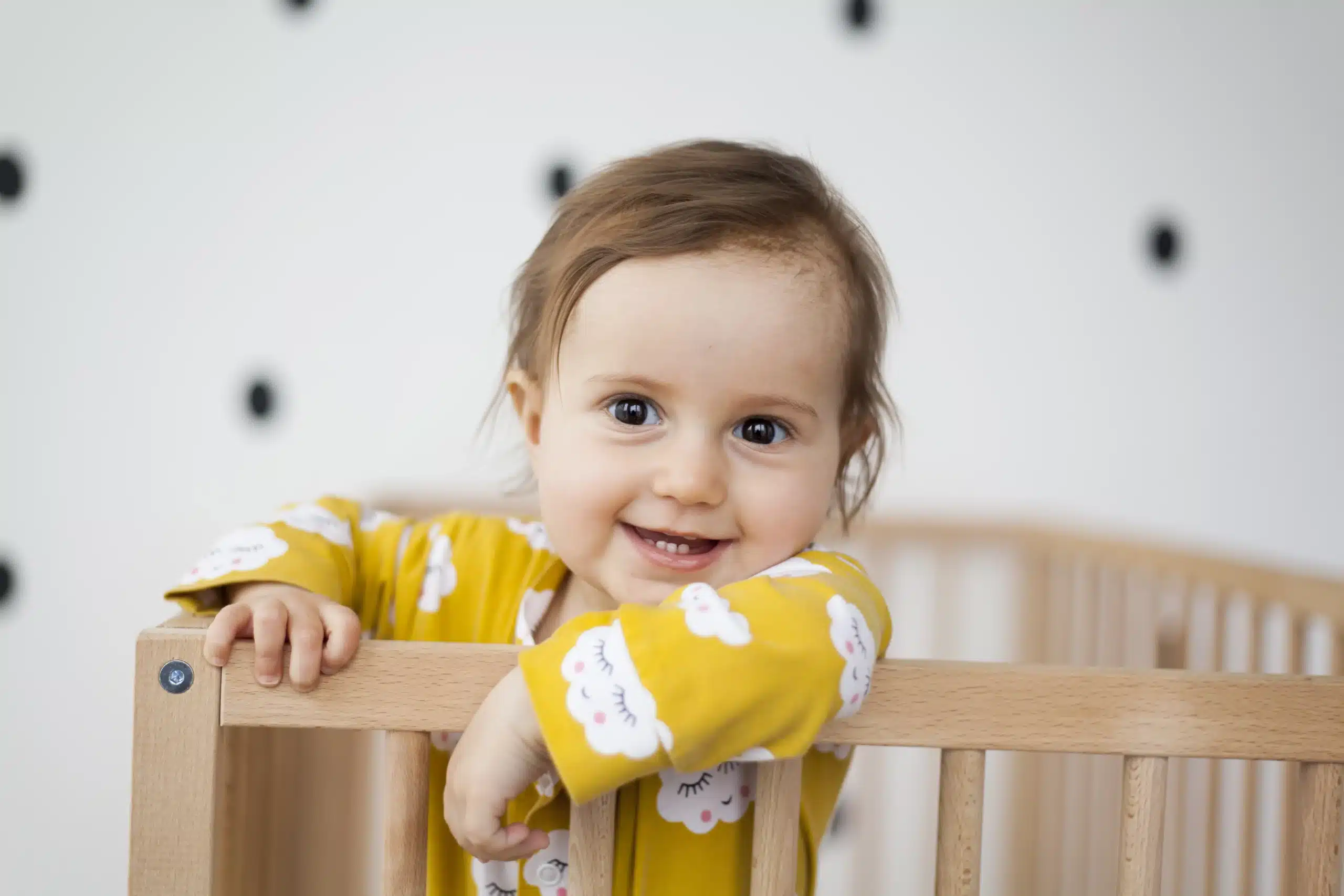 Toddler standing in a cot