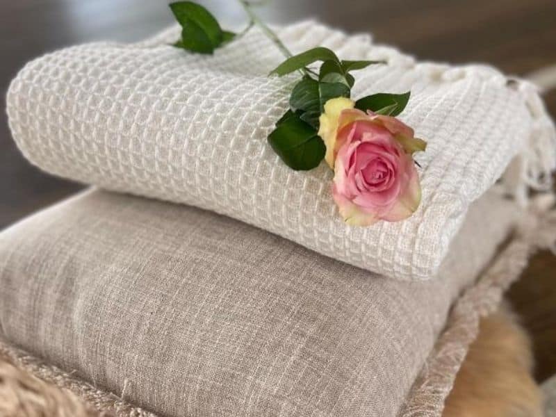 A pink flower lying on a white sheet