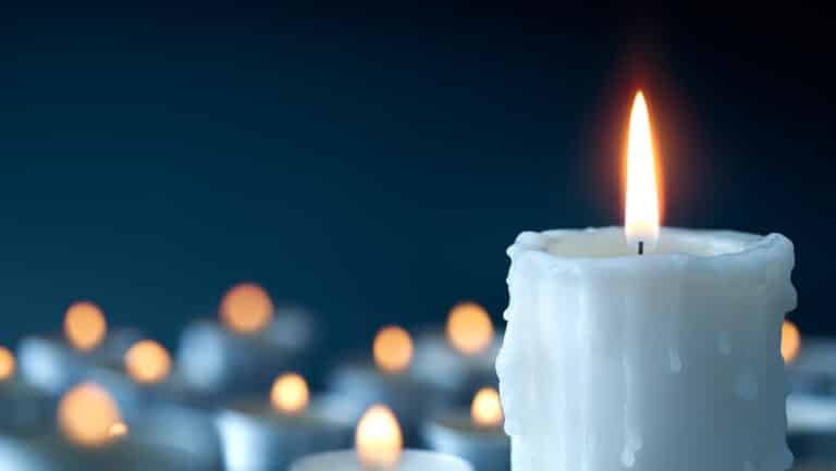 Melting candle on cool blue background