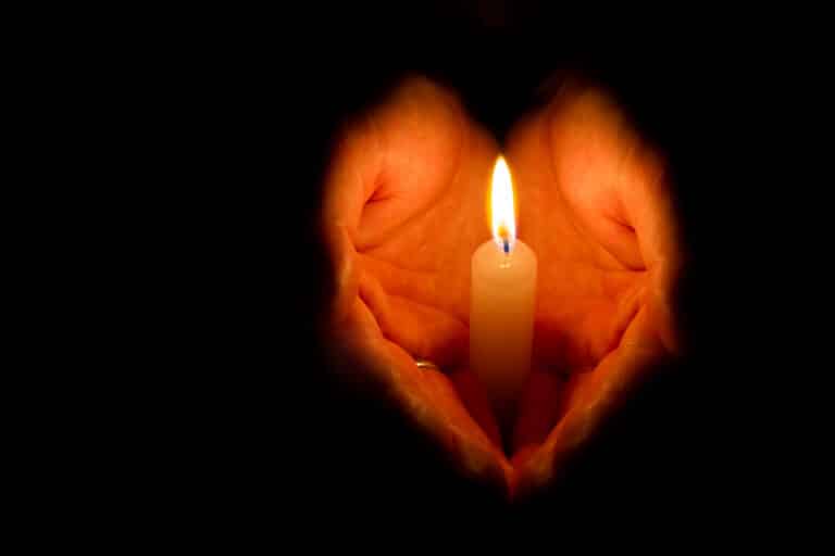 hands holding a burning candle
