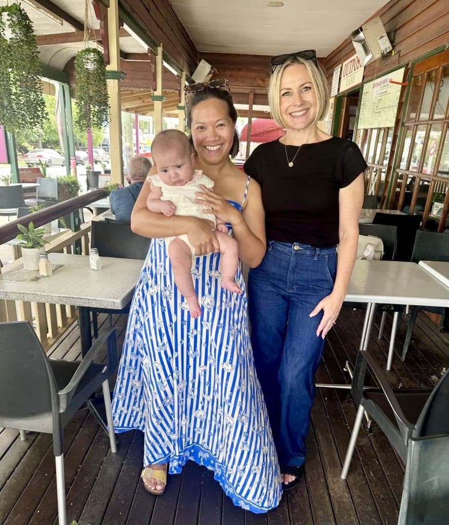 Judy holding her daughter Mila beside Sara Grant