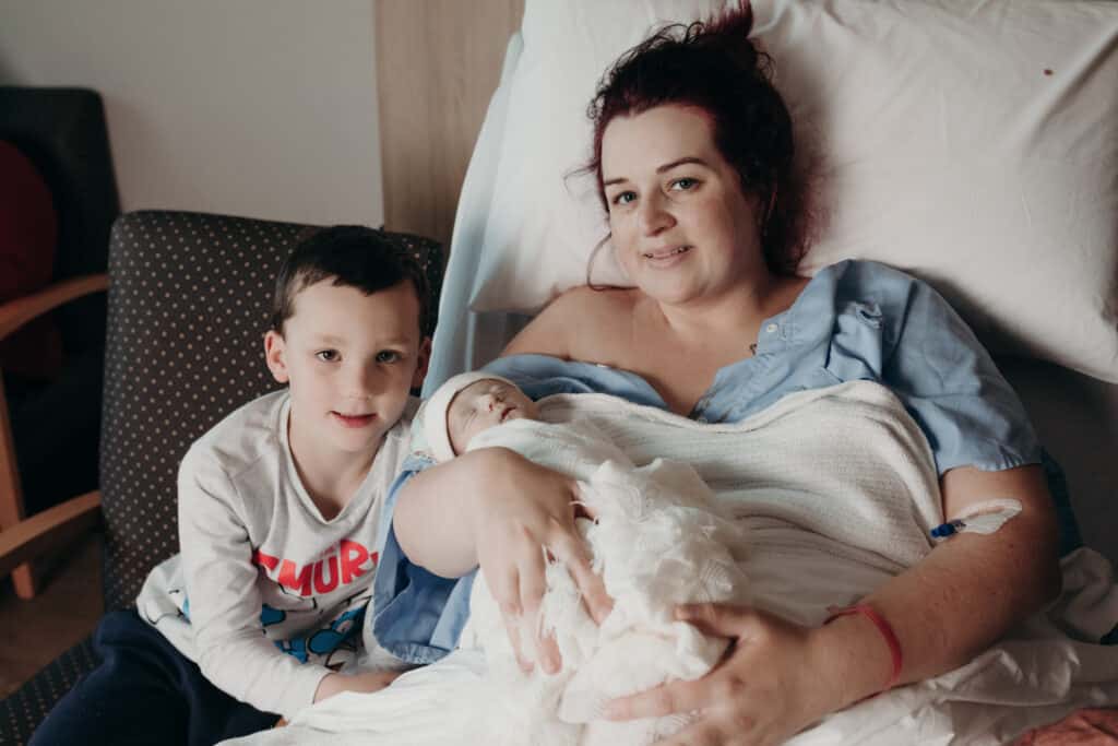 Alyssa holding her son Felix, with her son Lincoln beside her
