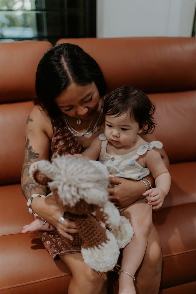 Roza holding her daughter Emi and the toy she made to hold Áva's ashes