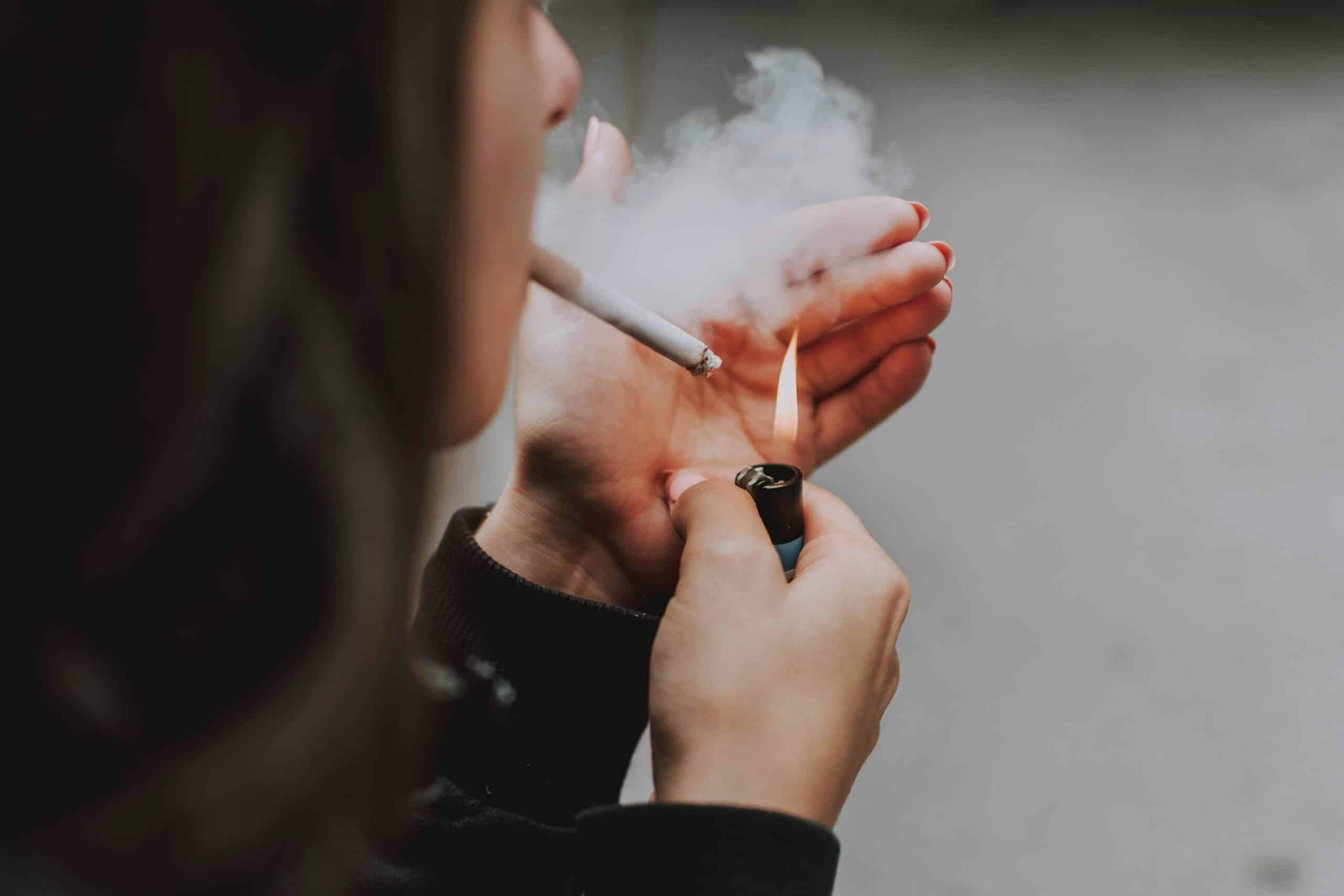 Woman lighting a cigarette. Quitting smoking helps with stillbirth prevention