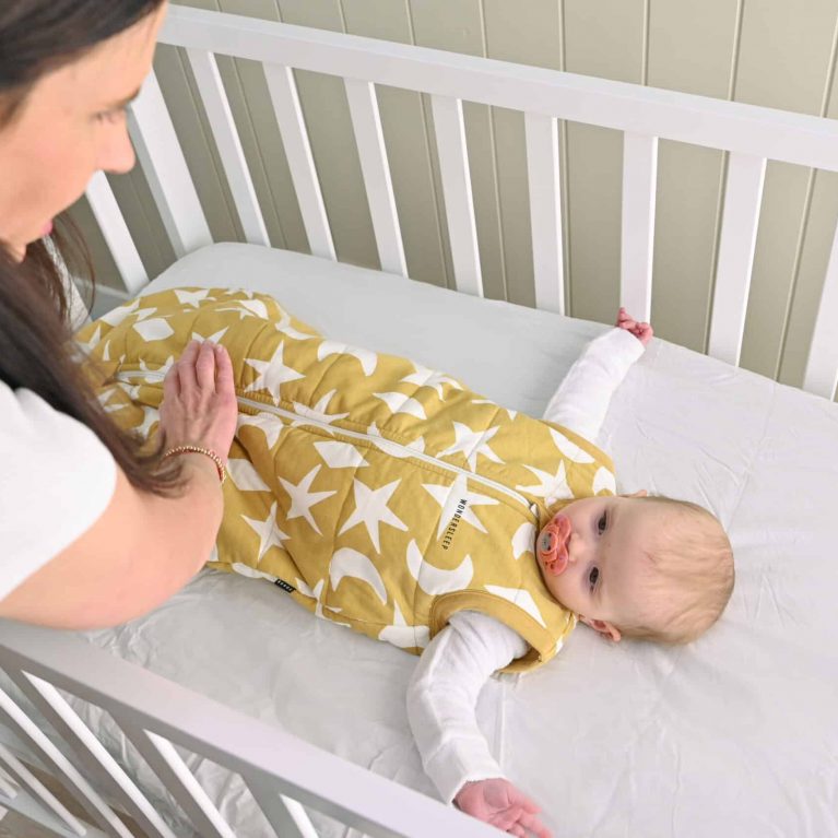 Baby lying down in cot