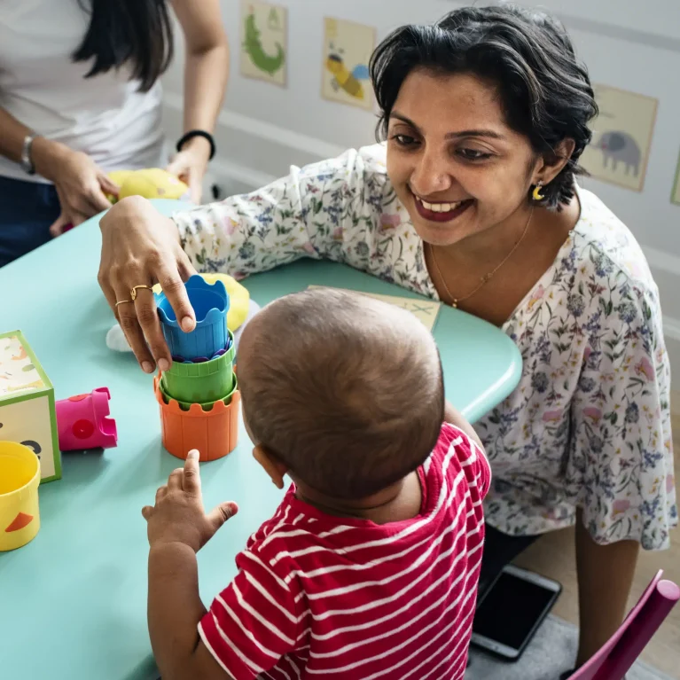 Educator at child care centre playing with a toddler