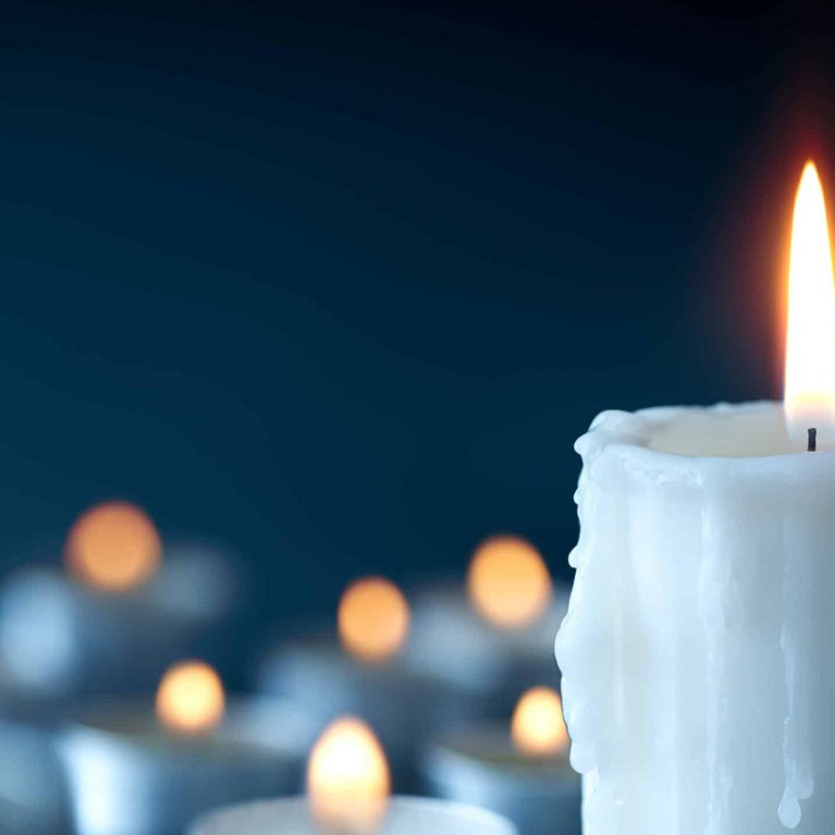 Melting candle on cool blue background