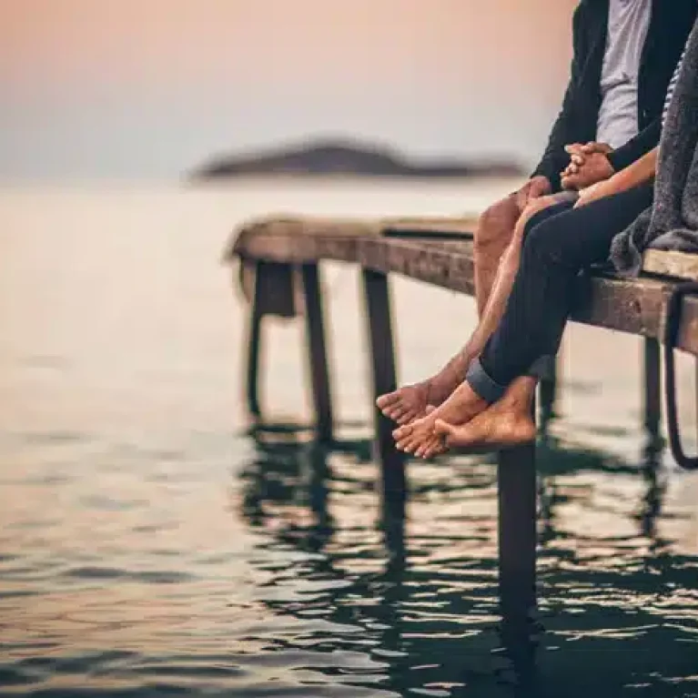Couple sit on a wooden peer